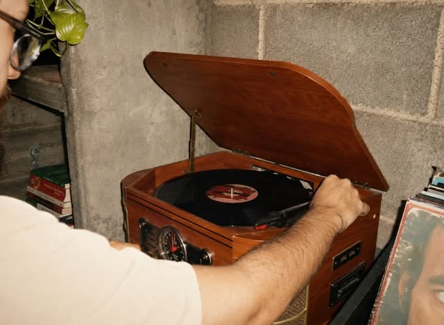 Disco de vinil tocando em uma vitrola de madeira na Pausa.